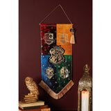 Harry Potter Hogwarts Houses fringed wall banner, pointed pennant quartered in red, orange, blue and green with gold house crests and central Hogwarts shield, tassel detail, hung on a dark red wall.