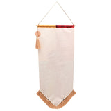 Fringed wall banner with pointed hem, cream fabric top panel in yellow and red tones, tan tassel and fringe trim, hung from a cord against a plain white background.