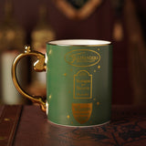 Green porcelain mug with gold handle, featuring Ollivanders, Flourish and Blotts, and Wiseacre's Wizarding Equipment shop emblems in gold script, set on a dark leather surface.