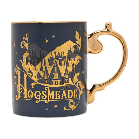 Harry Potter Hogsmeade Collectable Mug in dark blue ceramic with a gold handle, featuring a gold village scene, swirling leaves, stars and lettering, shown on a white background.