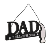 Black wooden wall plaque spelling DAD with cut-out letters, "You're A Super Daddy" text and star details, forming a hammer with silver mirror-effect head, hung on cord against a white background.