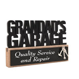 Wooden standing plaque with tall black cut-out letters reading Grandads Garage above a wood base with black panel text Quality Service and Repair and a hanging silver tool charm.