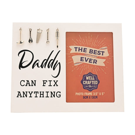 White wooden photo frame reading "Daddy Can Fix Anything" in black script, with five hanging silver tool charms and a 3.5x5in photo opening.