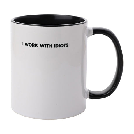 White stoneware mug with black interior and handle, printed with "I WORK WITH IDIOTS" in bold black capitals, 11oz, on a plain white background.