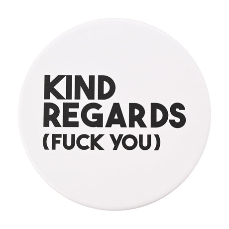Round white matt ceramic coaster printed with bold black text reading "KIND REGARDS (FUCK YOU)", shown on a plain white background.