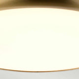 A close-up of the Welland LED Light Mini Flush - Aged Brass against a soft background highlights its sleek and modern design. The round, gold-colored light features a smooth surface and warm tone, encapsulating elegance and simplicity with its aged brass finish.