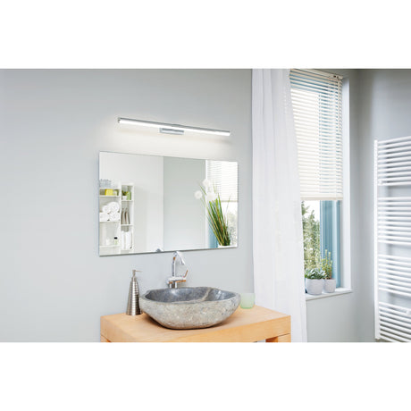 Wenelle LED Bathroom Wall Light in chrome, a slim 78cm bar fixture with white diffuser mounted above a rectangular mirror in a light grey bathroom.