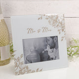 Square grey glass photo frame with gold glitter floral corners and "Mr & Mrs" script, holding a 6 x 4in landscape photo, shown against a light backdrop.