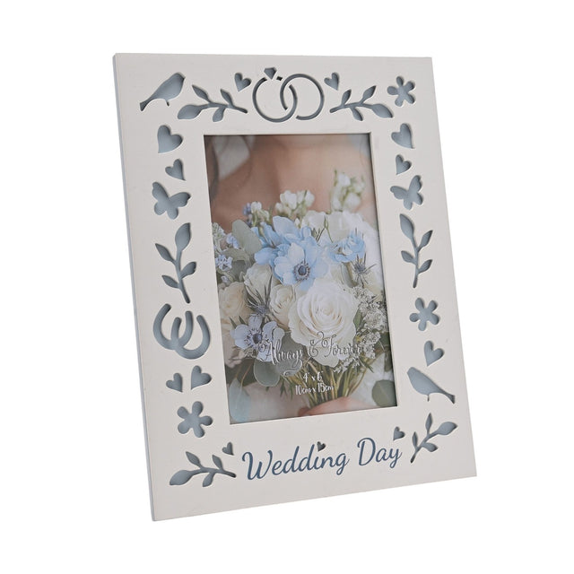 White laser cut wooden photo frame for a 6x4in portrait photo, with "Wedding Day" script, linked rings, birds, hearts and butterflies cut through to blue backing.