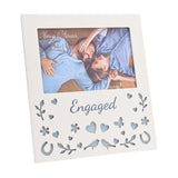 Cream wooden 6 x 4in photo frame with "Engaged" script below the picture window, its lower half cut through with hearts, flowers, a butterfly, leafy sprigs, horseshoes and facing birds.