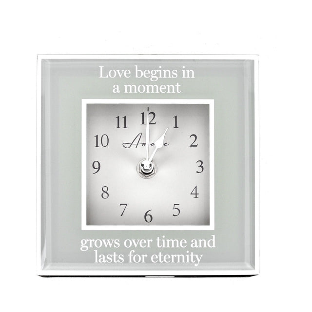 Square mantel clock, 15cm, with mirrored grey border and white dial, reading "Love begins in a moment, grows over time and lasts for eternity," on a plain white background.