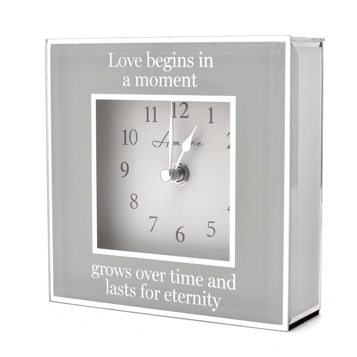 Square mantel clock, 15cm, with mirrored grey border and white dial, inscribed "Love begins in a moment, grows over time and lasts for eternity," on a plain white background.