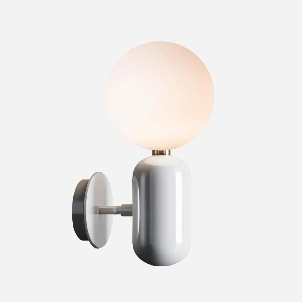 The Pallo Wall Light - White is a contemporary wall sconce featuring a streamlined, white cylindrical base and an opal glass diffuser. It provides a warm glow that elevates its minimalist design, bringing elegant simplicity to any plain background.