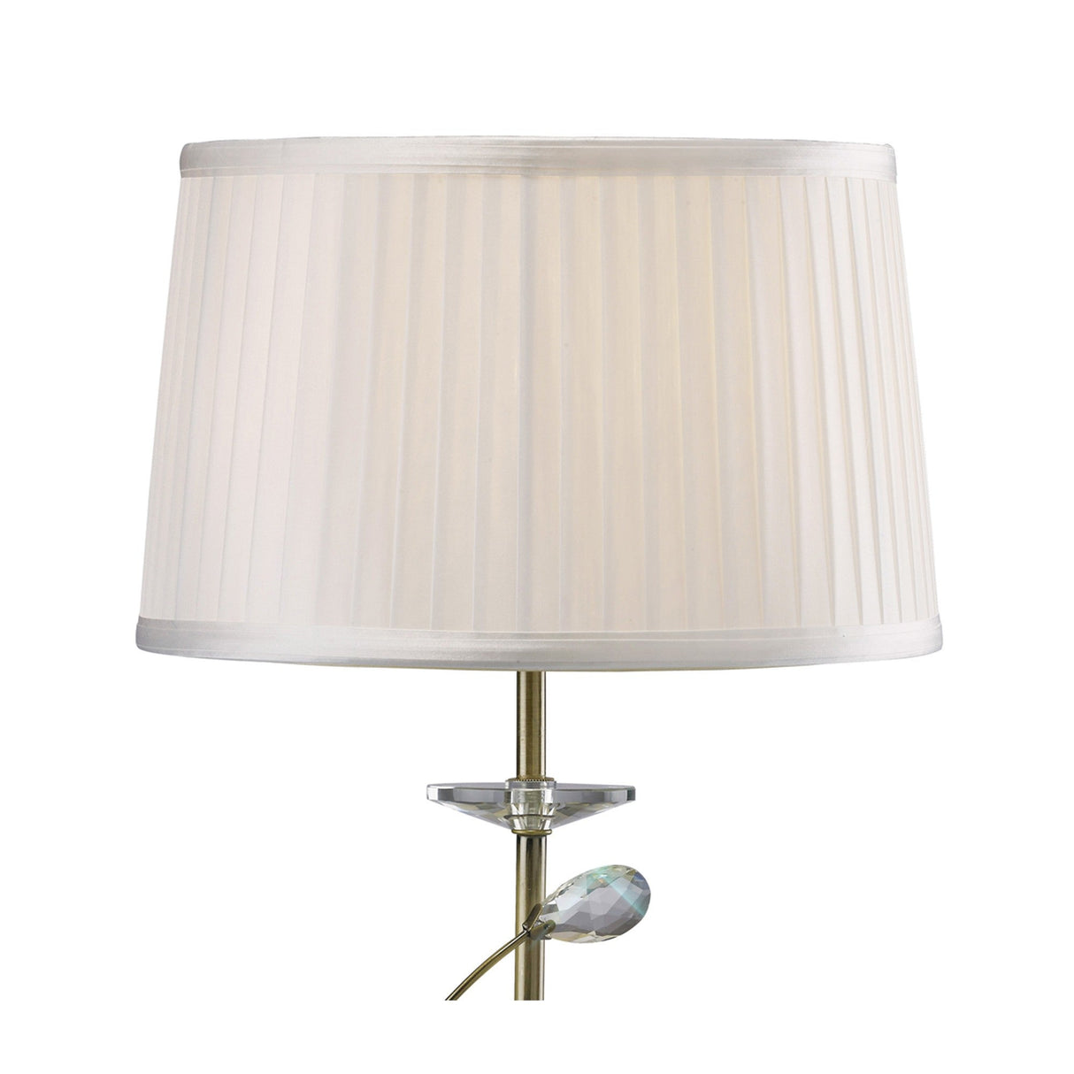 The Willow 1 Light Crystal Table Lamp features an antique brass finish, clear crystal accents near the stem, and is topped with a white pleated shade, shown here against a plain white background.