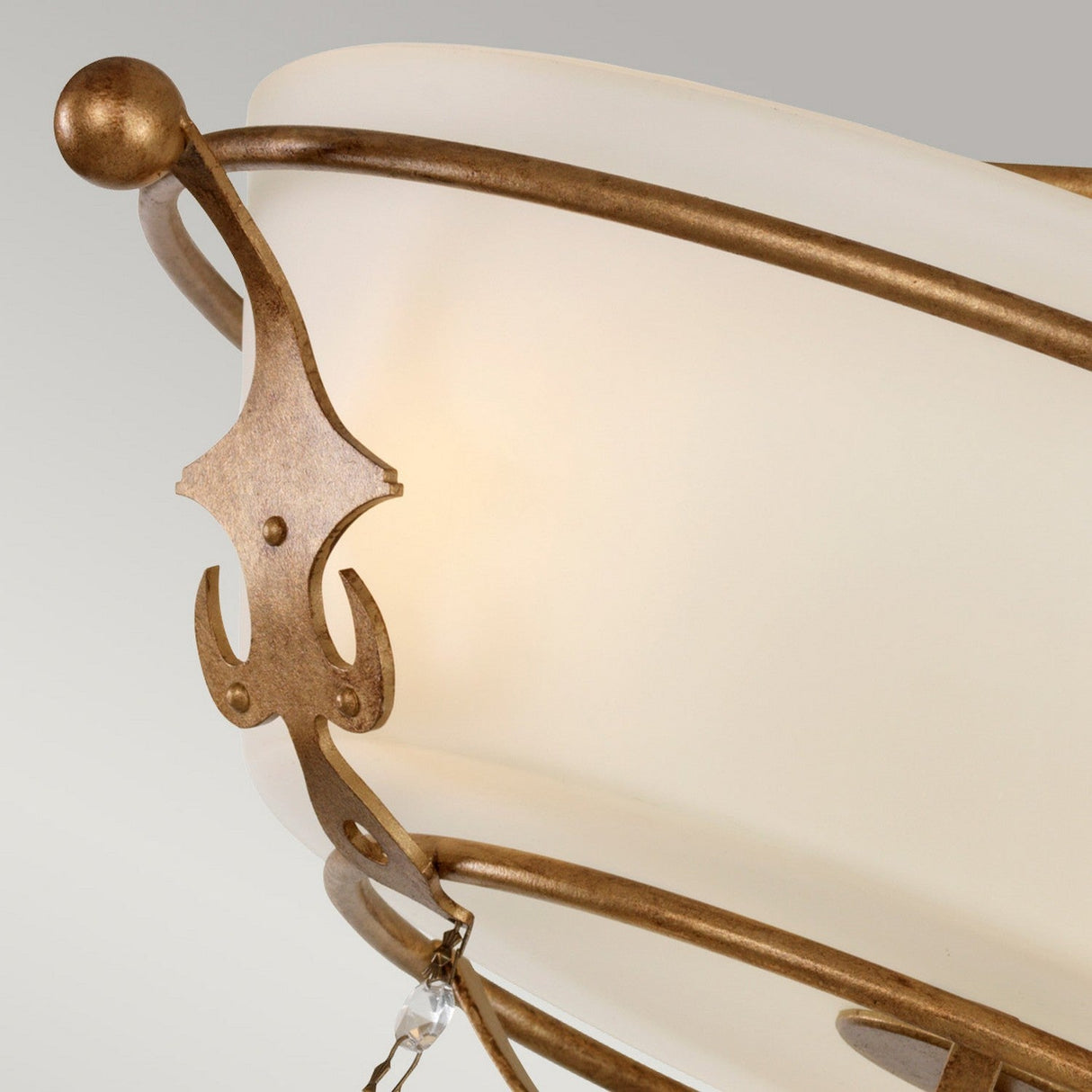 Close-up of the Windsor 3 Light Chandelier in Gold Patina, showcasing a bowl-shaped design with a frosted glass shade and bronze metal accents, featuring curved supports and decorative finials against a plain gray background.