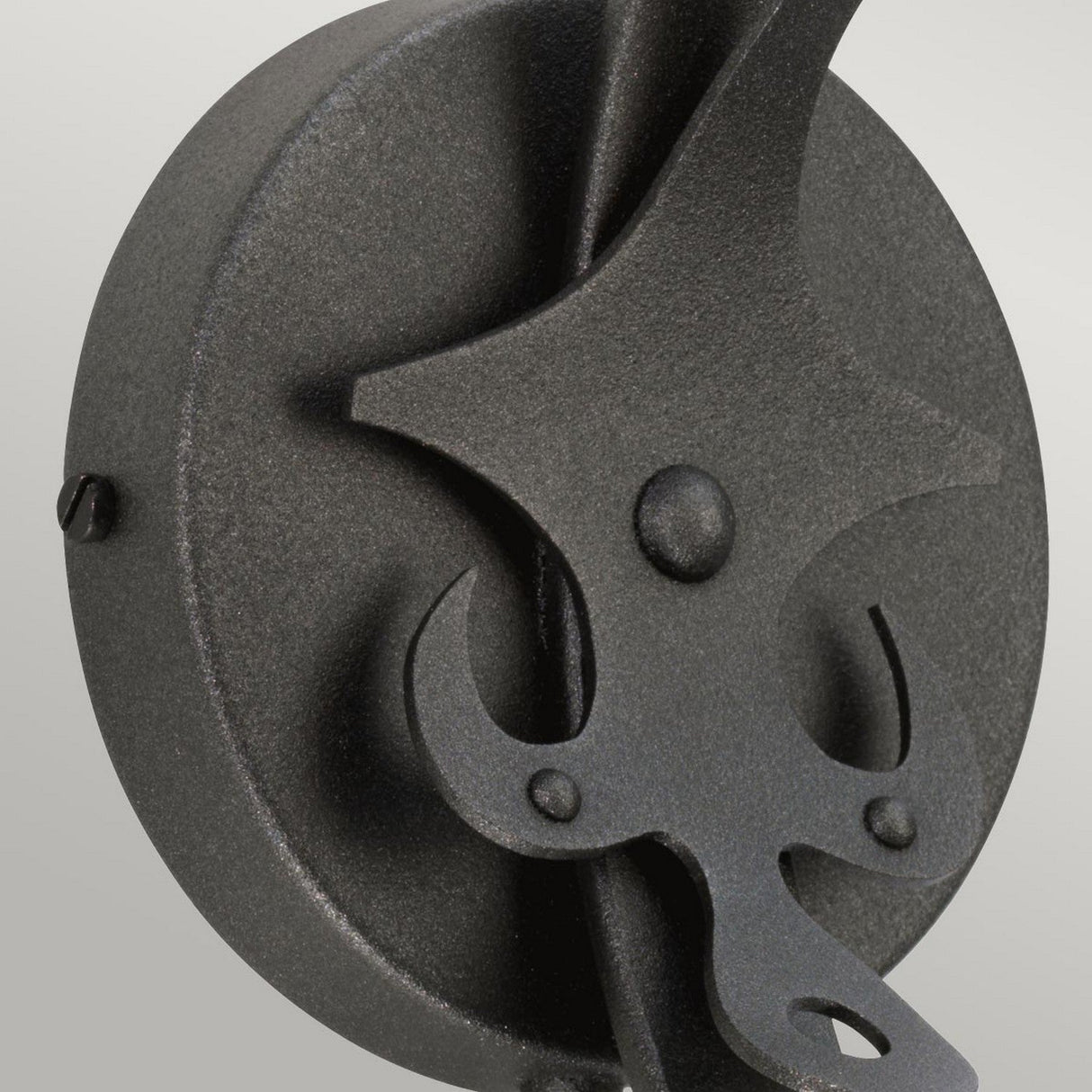 Close-up of the Windsor 1 Light Wall Light in a graphite finish, showcasing a star design and curving hook elements, set against a light gray background.