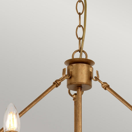 The Windsor 12 Light Chandelier - Gold Patina features a detailed close-up showing metal rods radiating from the center, with a candle-like bulb on the left. This elegant brass fixture, showcasing exquisite British craftsmanship, hangs by a chain against a plain light gray background.