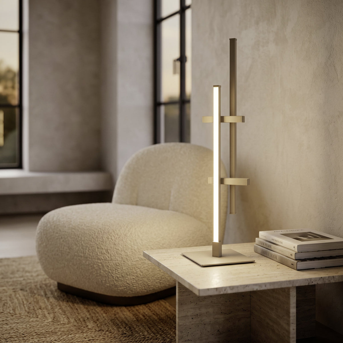 Wirmane LED Table Lamp in sand on a living room coffee table, with offset vertical bars and crossbars in aluminium and steel, a glowing white diffuser strip, beside a boucle chair.