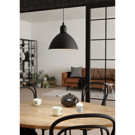 Wirnorne Pendant Light 30.5cm in black steel with a white interior, dome-shaped shade on a black cord, shown above a wooden dining table in a living space.