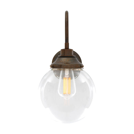 Wistella Glass Swan Neck Globe Wall Light IP44 in antique brass, with a clear glass globe and visible filament bulb on a round wall plate, shown against a plain white background.