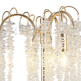 A close-up of the Wisteria 3 Light Table Lamp in gold, showcasing decorative metal arches with hanging clear crystal clusters and exposed LED bulbs that emit a warm, dimmable glow.