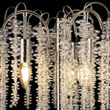 Close-up of the Wisteria 3 Light Table Lamp, featuring nickel finish and clear crystal clusters on curved arms with three exposed bulbs, creating elegant ambient lighting against a black background.