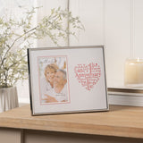 Silver metal 40th Anniversary photo frame holding a couple's portrait, with a red heart-shaped word design reading "Anniversary" on a white mount, shown on a wooden sideboard.