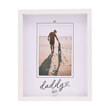 White freestanding photo frame with "daddy" script and heart details below a 6 x 4in portrait photo of a man and child walking on a beach.