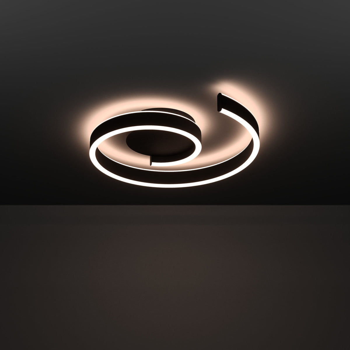 Andabaia Smart LED Flush Ceiling Light in black, an open spiral band of aluminium and steel with a warm white diffuser, mounted on a dark ceiling.