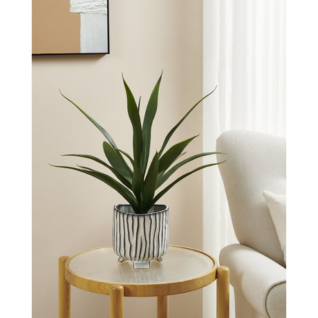 Wormiston Ceramic Plant Pot 17cm in white and brown with raised vertical stripes and small feet, shown on a side table with a faux plant in a living room setting.