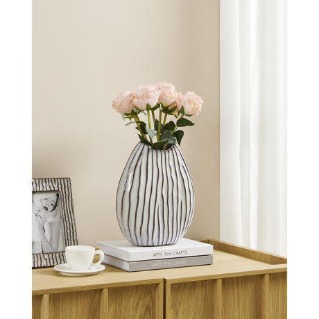 Wormiston Ceramic Vase 25.3cm in white with fine brown stripes and a wavy rim, holding pink roses on a sideboard beside books and a teacup.