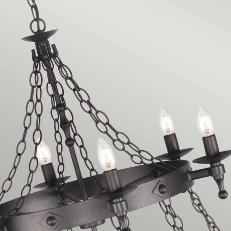 A Warwick 18 Light Chandelier in Graphite Black, featuring a circular medieval design with six candle-shaped light bulbs, is suspended from multiple linked chains against a plain white background.