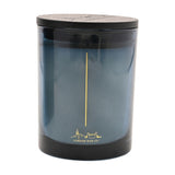 Dream & Cocoon round scented candle in a blue glass vessel with black lid, gold wick line and London skyline design, on a plain white background.