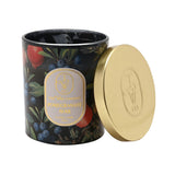 Pomegranate Noir Glass Scented Candle, 190g, round black jar printed with pomegranates, blueberries and leaves, gold lid resting beside it, on a plain white background.