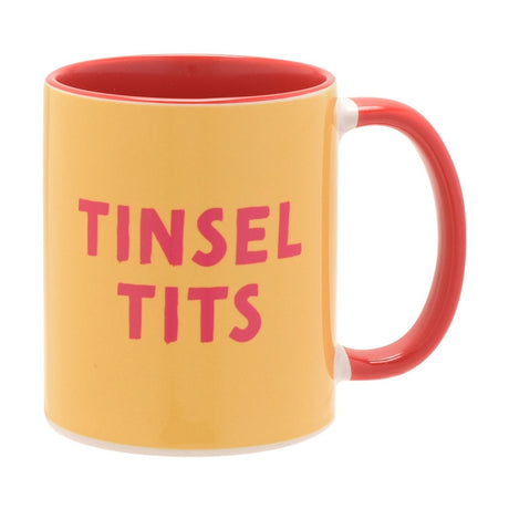 Stoneware mug with red handle and interior, yellow body printed with "TINSEL TITS" in bold red lettering, 11oz, on a plain white background.