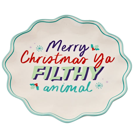 Round white stoneware plate with wavy teal-edged rim, featuring "Merry Christmas Ya FILTHY animal" in colourful lettering with holly accents, on a plain white background.