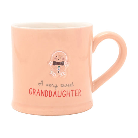 Pink stoneware mug with an embossed gingerbread man, bow tie and buttons, reading "A very sweet GRANDDAUGHTER" in script and red capitals, on a white background.