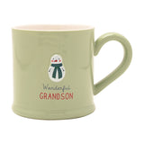 Green stoneware mug with an embossed snowman in a striped scarf, "Wonderful GRANDSON" text below, pink interior, on a plain white background.