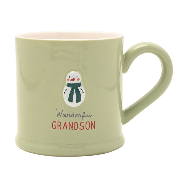 Green stoneware mug with an embossed snowman in a striped scarf, "Wonderful GRANDSON" text below, pink interior, on a plain white background.