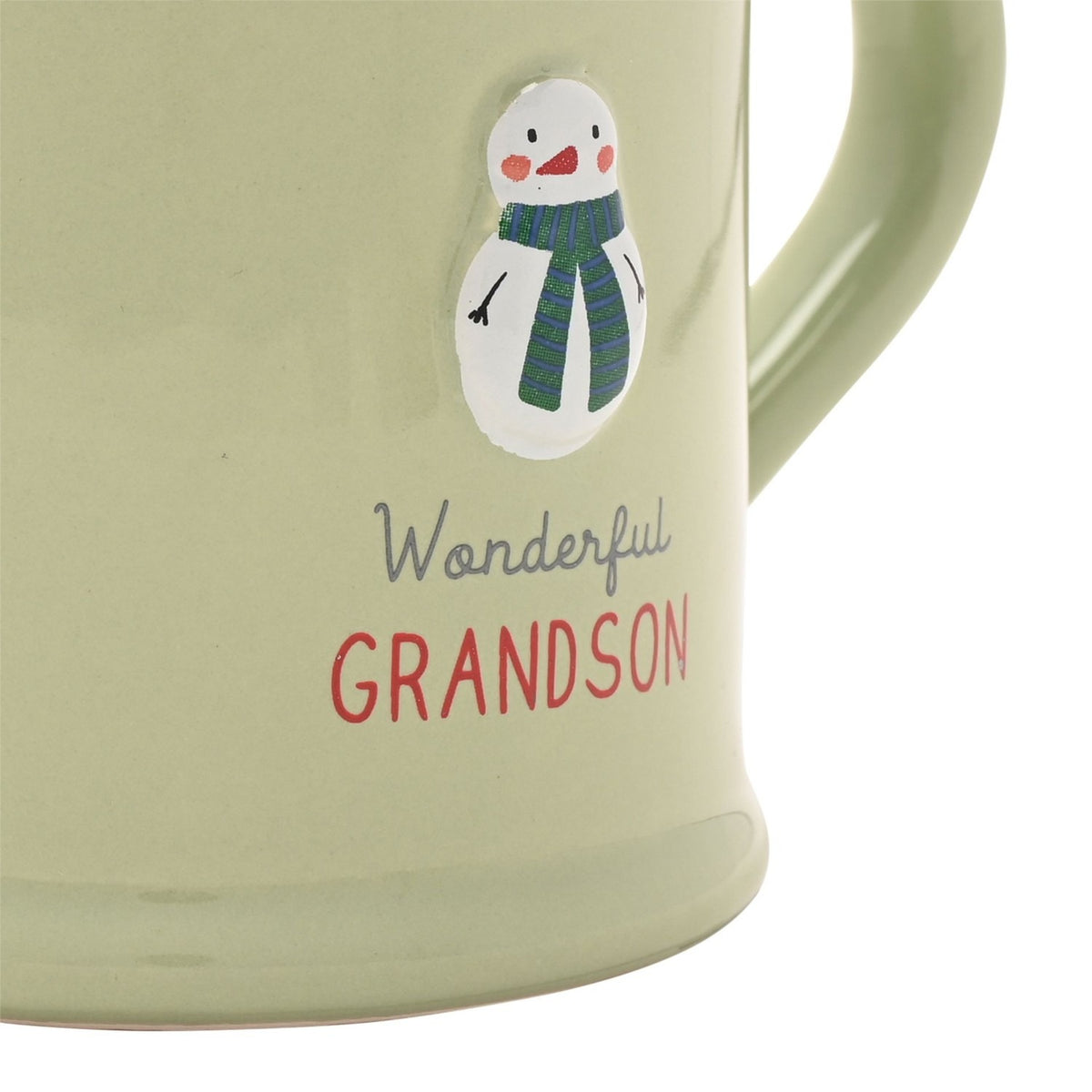 Close-up of a green stoneware mug with an embossed snowman in a striped scarf, reading "Wonderful GRANDSON" in grey script and red capitals.
