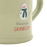 Close-up of a green stoneware mug with an embossed snowman in a striped scarf, reading "Wonderful GRANDSON" in grey script and red capitals.