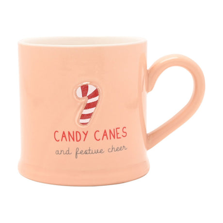 Pink stoneware mug with a raised candy cane design and "CANDY CANES and festive cheer" text, white interior, on a plain white background.
