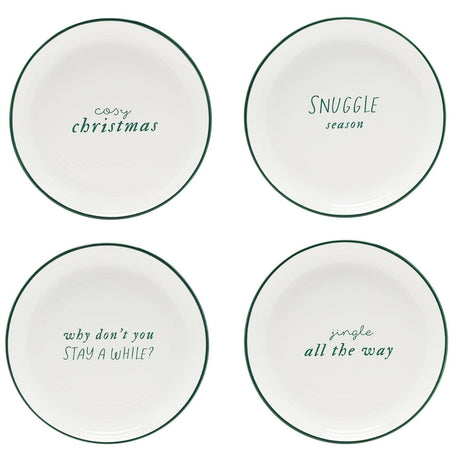 Four small round stoneware plates with glossy white glaze and dark green rims, each lettered in green with a different cozy holiday phrase, on a plain white background.