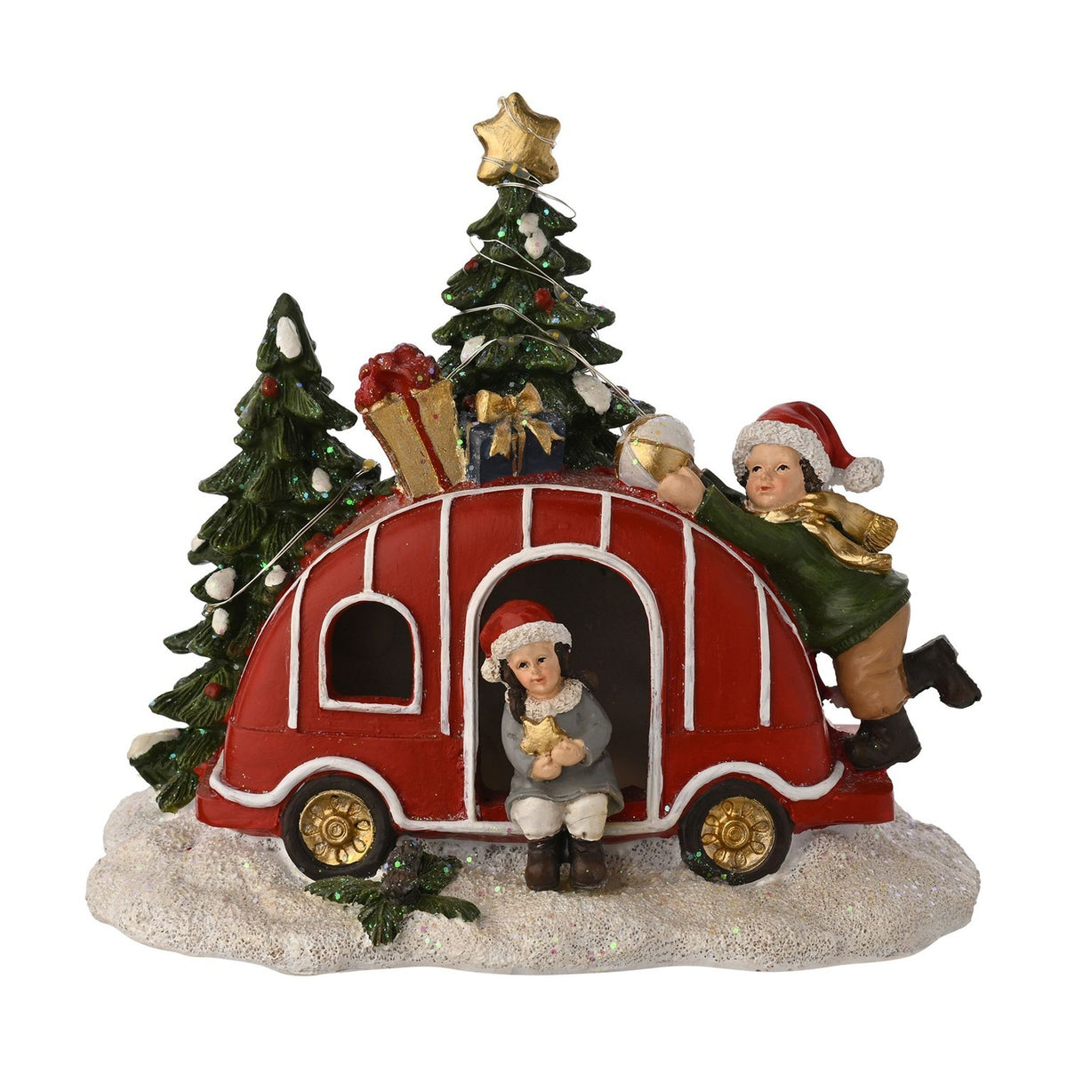 Light-up Christmas Caravan decoration in red plastic with white trim and gold wheels, roof piled with gifts, two Santa-hatted children figures, snowy trees, white background.