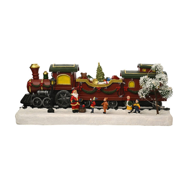 Christmas Train Scene light-up decoration with red steam engine, wagon of presents and teddy bear, carriages with green roofs, Santa and children figures on a snowy white base, plain background.