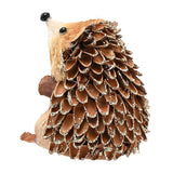 Straw hedgehog ornament with a pine-cone textured back featuring glitter-edged spines, straw bristled face, black nose and eyes, shown on a plain white background.
