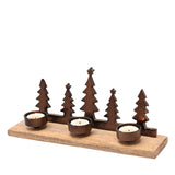 Bronze metal candle holder with five Christmas tree silhouettes of varying heights on a wooden base, fitted with three round tealight cups holding lit candles, shown on a plain white background.