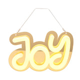 Gold mirrored plastic "Joy" LED neon hanging decoration with rounded white letters glowing warm yellow, hung on a thin cord against a plain white background.