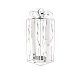 Silver metal tealight candle holder shaped like a Christmas present, with wavy wire sides, a flat ribbon band, arched front opening, and a looped bow on top, set against a plain white background.