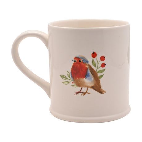 White stoneware mug with a loop handle, featuring a painted robin with red breast beside green leaves and red berries, on a plain white background.